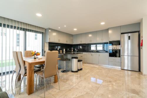 a large kitchen with a table and a refrigerator at Casa Barros Serra in Calheta