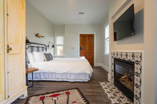 een slaapkamer met een bed en een open haard met een flatscreen-tv bij Radiant Rancher in Denver