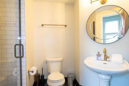 een badkamer met een toilet, een wastafel en een spiegel bij Radiant Rancher in Denver