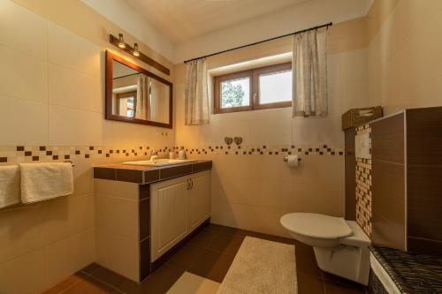 La salle de bains est pourvue de toilettes, d'un lavabo et d'une fenêtre. dans l'établissement Drevenica Huty, à Huty