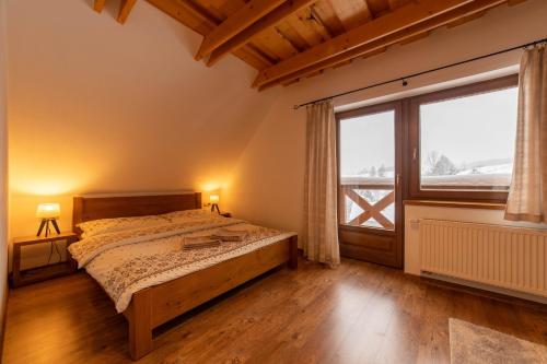 a bedroom with a bed and a large window at Drevenica Huty in Huty