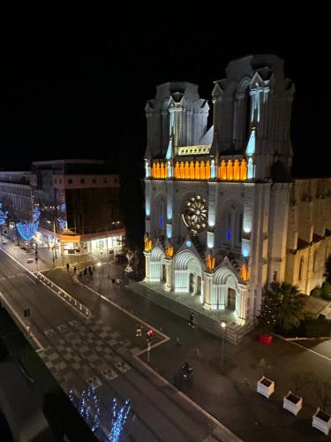 a large building with a clock tower at night at Studio NICE CENTRE sur Avenue Jean Medecin MER à 8 minutes de marche in Nice