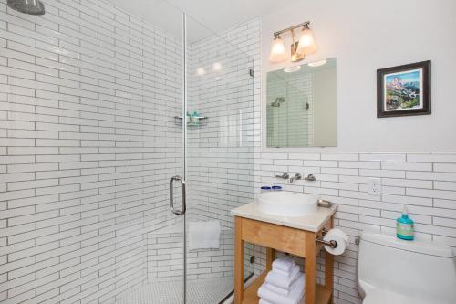 a white bathroom with a sink and a shower at The Alpine House in Jackson