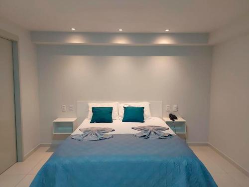 a bedroom with a blue bed with two blue pillows at Flat Frente Mar - Praia de Tabatinga in Conde
