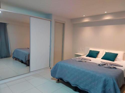 a bedroom with a bed and a large mirror at Flat Frente Mar - Praia de Tabatinga in Conde