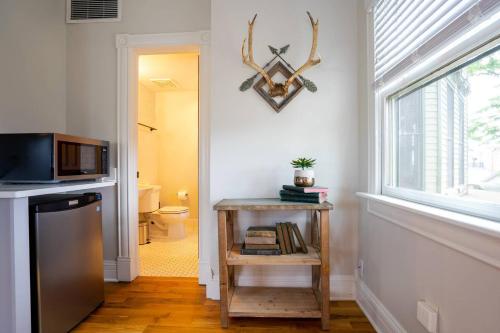 a hallway with a kitchen with a microwave and a window at Pinky's Palace in Denver