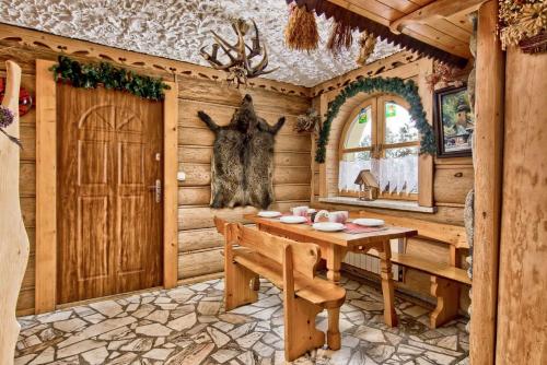 a dining room in a log cabin with a table and a door at Dom Wypoczynkowy GALICA in Poronin