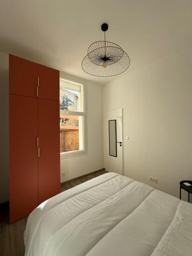 une chambre avec un grand lit blanc et une fenêtre dans l'établissement Appartement Secteur Gare et Place de la Comédie, Wifi et Climatisation, à Montpellier