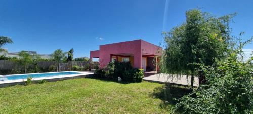 a pink house with a pool in a yard at Cielito Lindo Gualeguaychú in Gualeguaychú