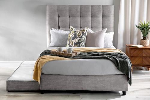 um quarto com uma cama com uma cabeceira cinzenta e almofadas em Feel Home em Pretoria