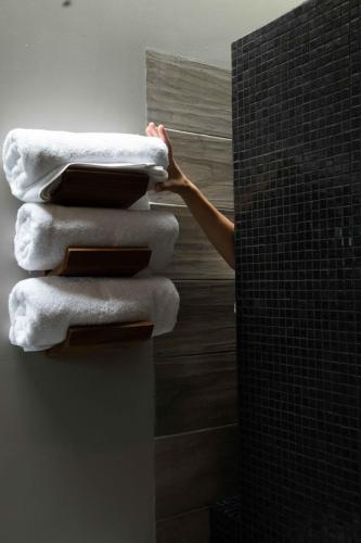 a person is stacking towels in a bathroom at El Callejón Hotel Boutique in Oaxaca City