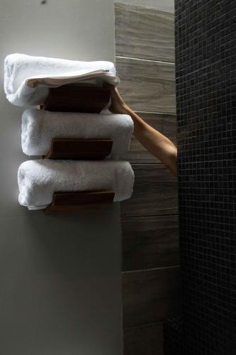 a stack of towels on a towel rack in a bathroom at El Callejón Hotel Boutique in Oaxaca City