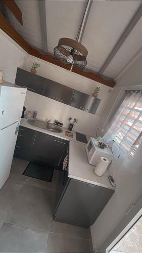 a small kitchen with a sink and a refrigerator at la savane in Terre-de-Haut