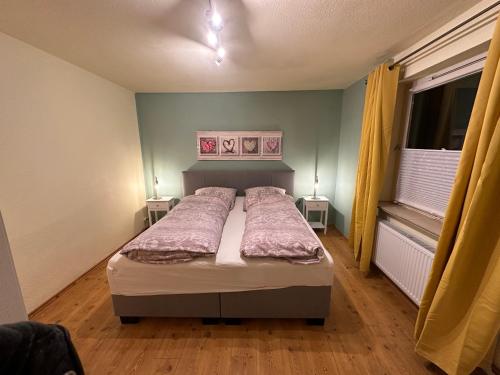 a bedroom with a bed and two lamps on two tables at Huck’s Ferienhäuser in Borstel