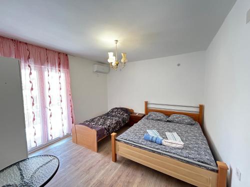 um pequeno quarto com uma cama e uma janela em Aniva Apartments em Šušanj