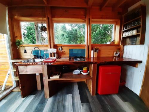 a kitchen with a large wooden island in a house at Tiny House Conguillio in Melipeuco