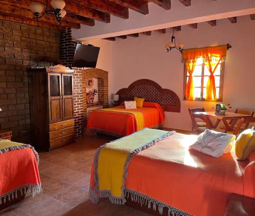 a bedroom with two beds and a window at Hotel El Aguila in Villa del Carbón