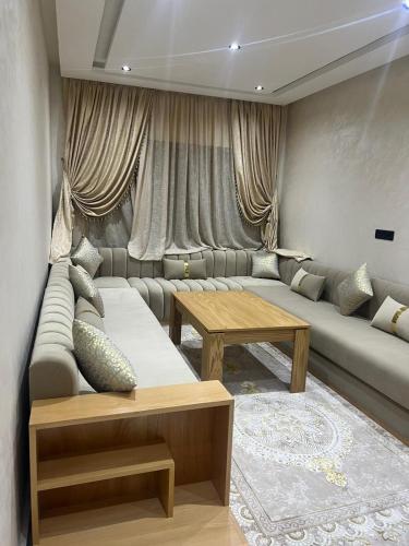 - un salon avec un canapé et une table dans l'établissement Résidence BAYTI, à El Jadida
