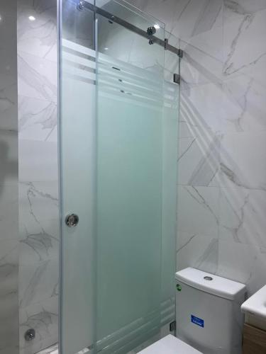 a bathroom with a shower with a toilet and a sink at Résidence Escalade 1 in El Jadida