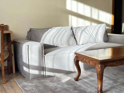 a silver couch in a living room with a table at Pigy in Tatariv