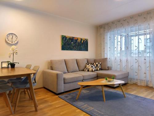 a living room with a couch and a table at HARAKA APARTMENT WITH SUNSET BALCONY in Tartu