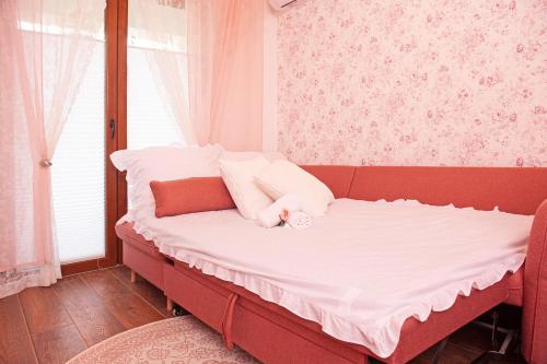 uma cama vermelha num quarto com uma janela em Vrnjačka Romansa Studio - Pešačka zona - Ravni deo - Baby friendly em Vrnjačka Banja