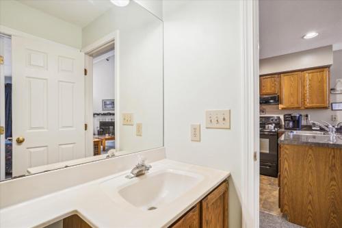 a bathroom with a sink and a kitchen at Spacious & cheerful Pico slopeside Condo Walk to lift & ski back! Pico 304 in Killington