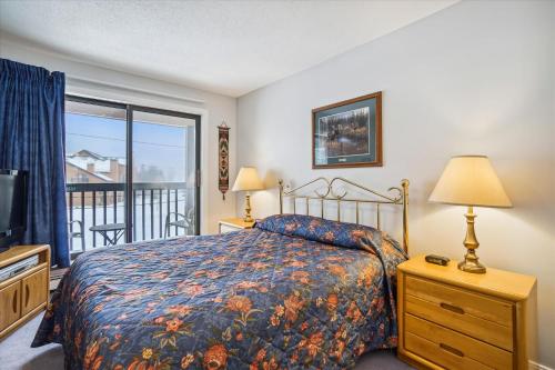 a bedroom with a bed and a balcony at Charming 2-Bedroom Slopeside at Pico Mountain E304 in Killington