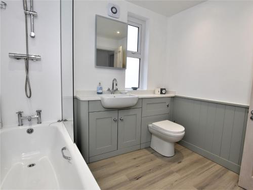 a bathroom with a sink and a toilet and a tub at 4 Bed in Ilfracombe 45121 in Ilfracombe
