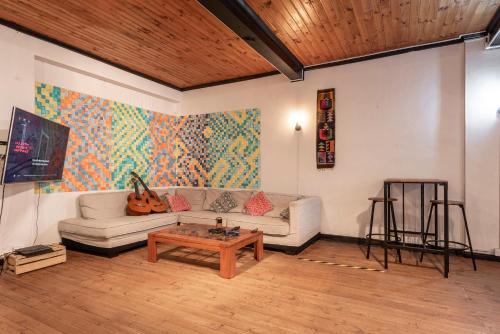 een woonkamer met een bank en een tafel bij LÖF Hostal in Pichilemu
