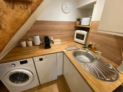 une cuisine avec une machine à laver et un évier dans l'établissement Charmant appartement - proche château cité, à Carcassonne