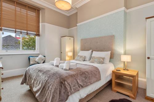 ein Schlafzimmer mit einem großen Bett und einem Fenster in der Unterkunft Spinnaker - Close to Town Sea Views in Tenby