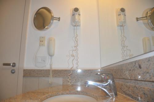 baño con 2 teléfonos y lavamanos en Flat em Resort com vista para o Mar! en Angra dos Reis