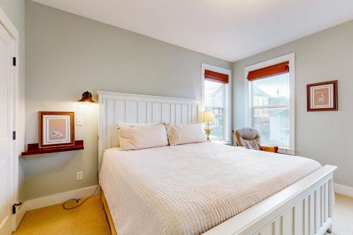 a white bedroom with a bed and a window at Jewel Box at the Beach in Lincoln City