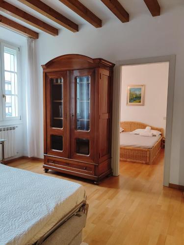 a bedroom with a wooden cabinet and a bed at 1Dest - City Center Charme in Riva del Garda