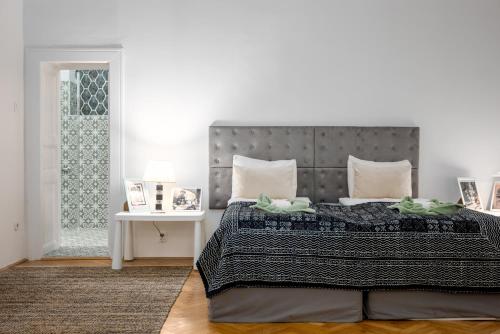 een slaapkamer met een groot bed en een tafel bij Bohémien Apartment in Boedapest