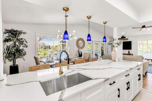 a kitchen with a sink and a living room at Surf Side in Anna Maria