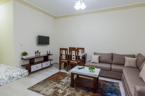 a living room with a couch and a tv at Lazur Sea & City Apartment's - El Hadaba, Hurghada - Egypt in Hurghada