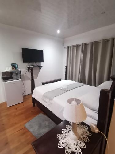 a bedroom with a bed and a table with a lamp at Palm Tree BnB in East London