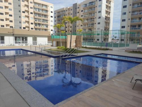 uma piscina com edifícios ao fundo em Aruana Azul 502 em Aracaju