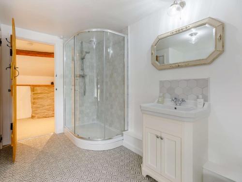 a bathroom with a shower and a sink and a mirror at 4 Bed in Hay-on-Wye 85357 in Michaelchurch Escley