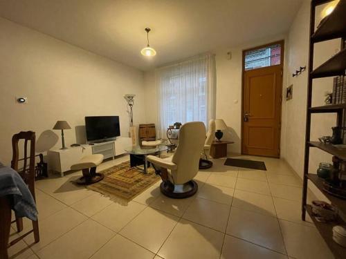 a living room with white chairs and a television at Charming City Home Near Downtown with Garage in Amiens