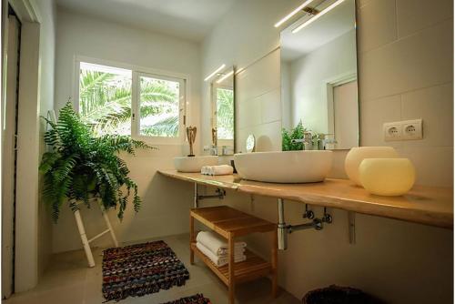 baño con 2 lavabos y espejo grande en Villa Tikal, en Can Furnet