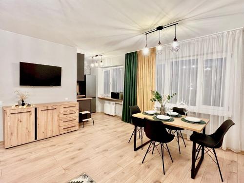 uma sala de estar com uma mesa e cadeiras e uma televisão em New Stylish Apartment City Center em Narva