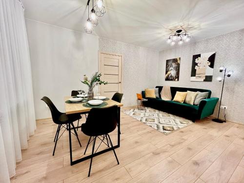 a living room with a table and a green couch at New Stylish Apartment City Center in Narva