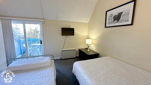 ブルー・マウンテンズにあるMountainview Loft at North Creek Resortのベッド2台と窓が備わるホテルルームです。