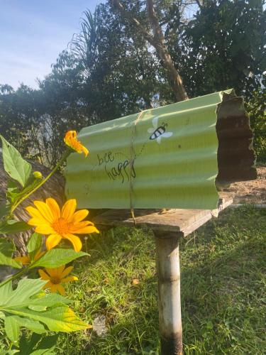 a green bird bath with writing on it next to flowers at Ecofinca in the mountains Azulita House in Cocorná
