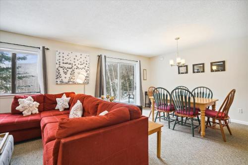 a living room with a red couch and a table at Cozy 2-Bedroom Northbrook #3 with Fireplace in Killington