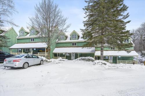 a car parked in the snow in front of a house at Cozy 2-Bedroom Northbrook #3 with Fireplace in Killington