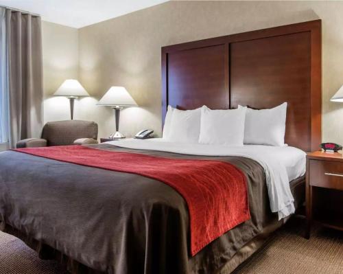 Habitación de hotel con cama grande con manta roja en Akwesasne Mohawk Casino Resort and Players Inn Hotel -formerly Comfort Inn and Suites Hogansburg NY, en Hogansburg